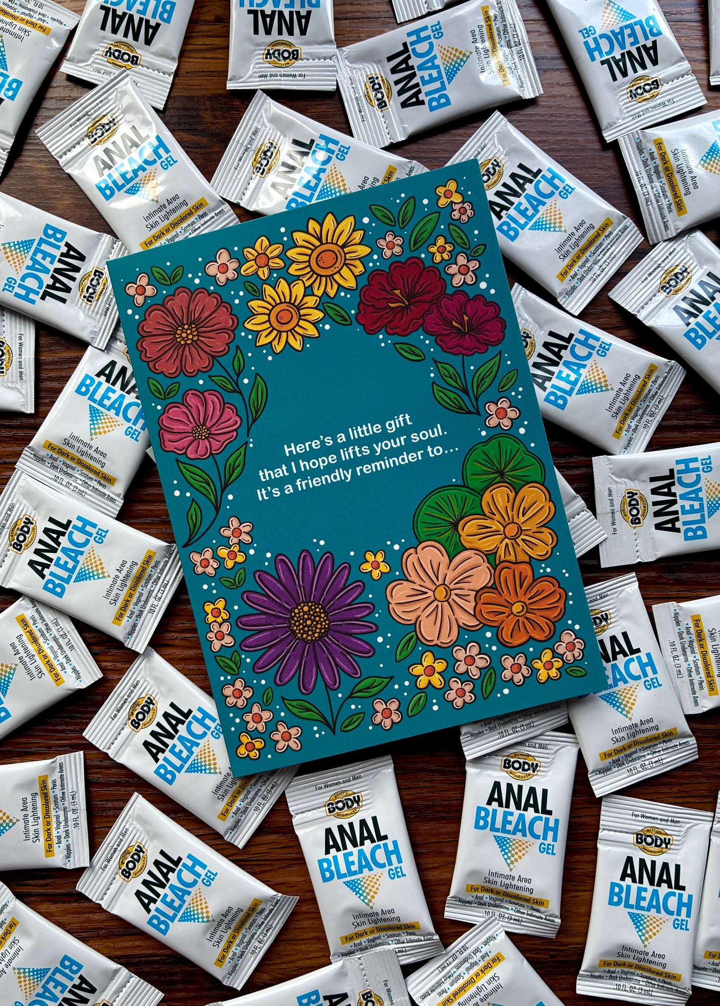 Front of Floral prank greeting card with anal bleach samples arranged around it.